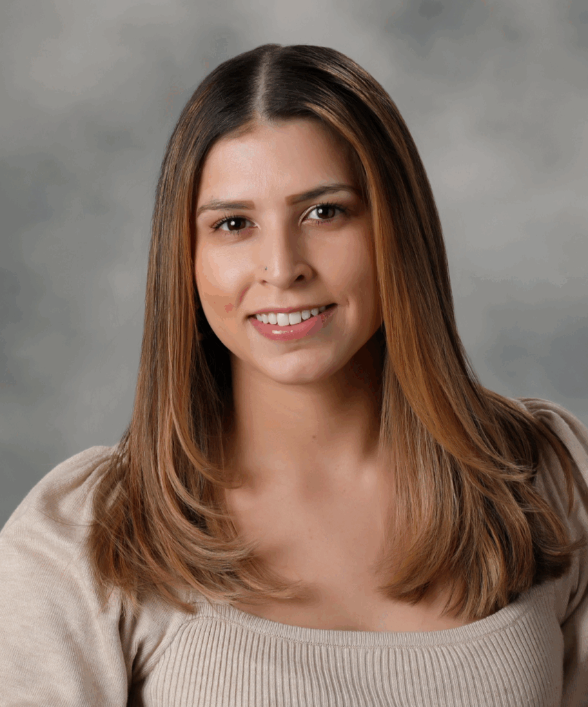 Portrait of a smiling woman with long ombré hair wearing a beige sweater.