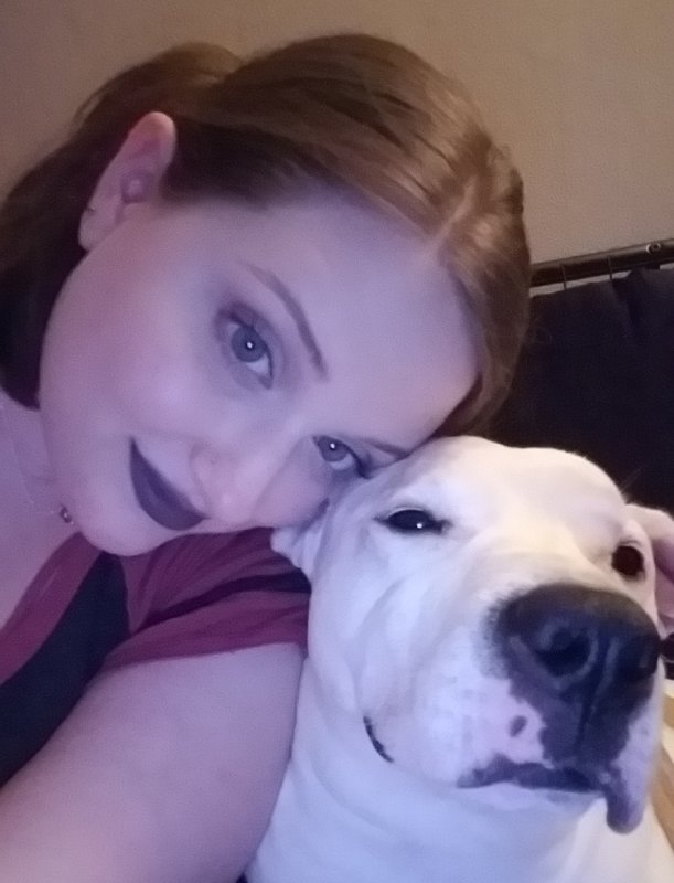 Woman and a large white dog posing closely for a selfie.